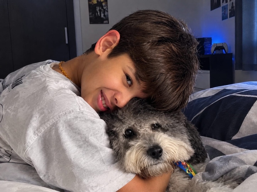Bernardo abraçado com o Cleitinho, o cachorrinho dele